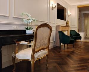 a living room with a chair and a desk at Lovelace Suites by Threads of Time Hotel Bruges in Bruges