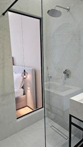 a bathroom with a glass shower with a couch in it at The Center 104 in Polisi i Vogël +3 photos