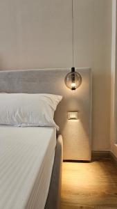 a bedroom with a white bed and a light at The Center 104 in Polisi i Vogël