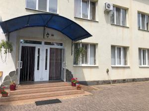 a front door of a house with a blue awning at Hotel Marianna in Berehove