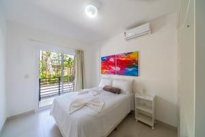 a bedroom with a bed and a painting on the wall at Areias de Itacimirim in Itacimirim +41 photos