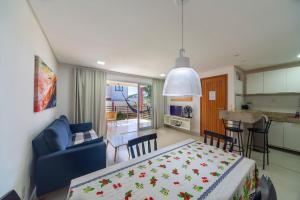 a living room and kitchen with a table and a blue couch at Areias de Itacimirim in Itacimirim
