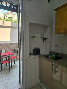 eine Küche mit Spüle und einem Tisch mit einem Tisch in der Unterkunft Ariam in Annaba