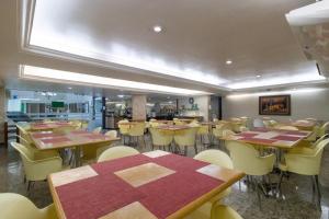 a dining room with tables and chairs in a restaurant at Hotel Nacional Inn Recife Aeroporto in Recife