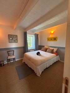a bedroom with a bed with a dog laying on it at Chambres Kergana in Landéda