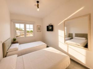 a bedroom with two beds and a mirror at Hostal la calma de Mascaraque in Mascaraque