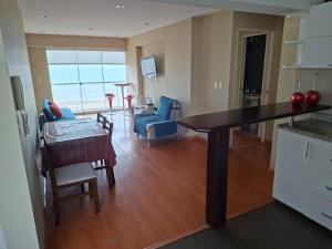 a kitchen and living room with a table and chairs at Beachfront Condo San Miguel in Lima