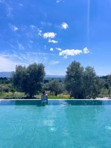 a person sitting in a pool of water at Puro Dão Hotel & Spa in Nelas