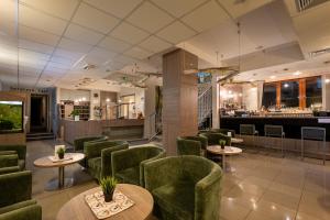 a restaurant with green chairs and tables and a bar at Hotel Bystrá in Brezno