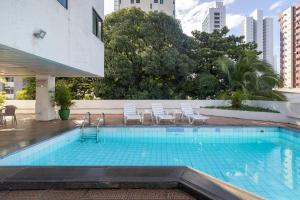 a swimming pool with chairs in a building at Hotel Nacional Inn Recife Aeroporto in Recife