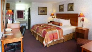 a hotel room with a bed and a desk at Magnuson Hotel Howell/Brighton in Howell