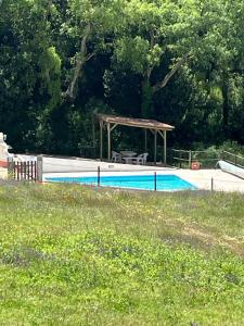 a swimming pool with a gazebo next to a field at Quinta Vale Formoso in Venda da Costa