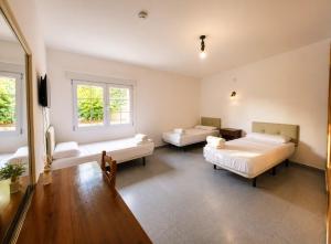 a large room with two beds and a tv at Hostal la calma de Mascaraque in Mascaraque