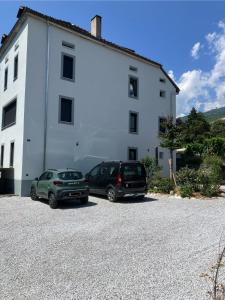 two cars parked in front of a white building at La Lanterne in Sierre