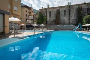 a large blue swimming pool next to an old building at Casa Vacanza San Pietro in Maiori