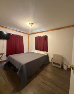 a bedroom with a bed with red curtains at Leapin leanas in Monson