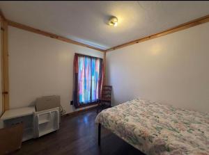 a small bedroom with a bed and a window at Leapin leanas in Monson