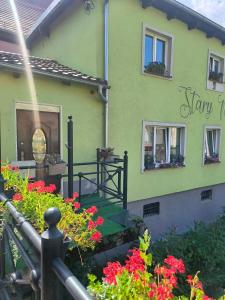 a green house with flowers in front of it at Apartament przy weneckim mostku in Kowary