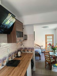 a kitchen with a wooden counter top and a dining room at Apartament przy weneckim mostku in Kowary