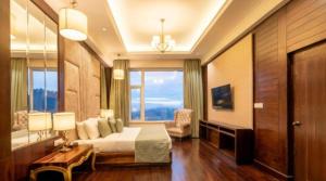 a hotel room with a bed and a large window at The velvet pines in Mukteshwar