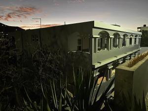 a white building with a sunset in the background at Djabraba's Rooms in Vila Nova Sintra