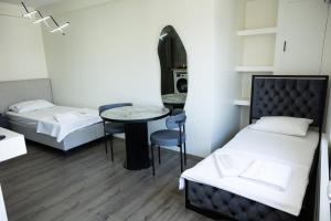 a room with two beds and a table in it at Ceylan Apart Otel in Tekirdağ +4 photos