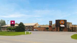 a building with signs on the side of a road at Magnuson Hotel Howell/Brighton in Howell