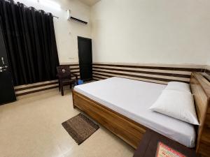 a bedroom with a bed and a chair in it at Shri Nimbark Mohini Kunj in Vrindāvan