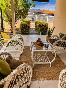 a patio with wicker chairs and a table at Recanto da Caatinga in Piranhas