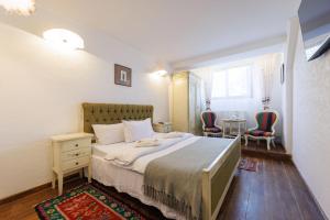a bedroom with a large bed and two chairs at Hanul Ancutei in Arămoaia