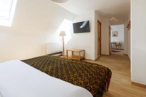 a hotel room with a bed and a television at Hanul Ancutei in Arămoaia