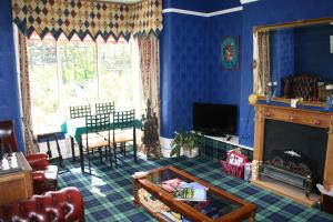 uma sala de estar azul com uma lareira e uma mesa em The Fairmile em Lytham St Annes