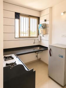a small kitchen with a stove and a refrigerator at Elite Nest Stay in Nashik