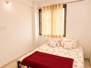 a bedroom with a bed with two pillows and a window at Elite Nest Stay in Nashik