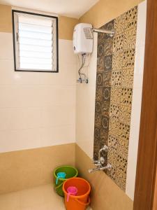 a bathroom with a shower with buckets and a window at Elite Nest Stay in Nashik