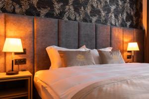 a bedroom with a large white bed with two lamps at Diplomatico Hotel in Odesa