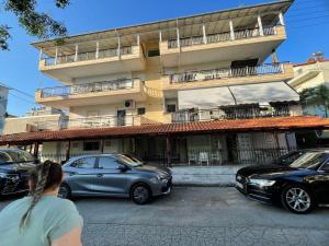 a woman walking down a street in front of a building at Olimpik bic in Paralia Katerinis