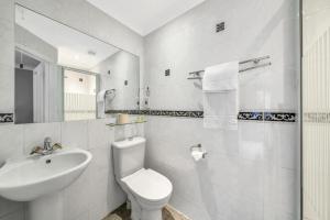 a white bathroom with a toilet and a sink at Seka Inn Hotel in Crowthorne +28 photos