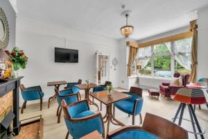 a living room with blue chairs and a table at Seka Inn Hotel in Crowthorne