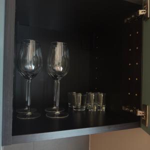 four wine glasses on a shelf in a wine cellar at City Center apartment in Jelgava in Jelgava