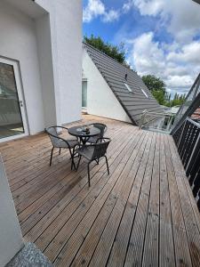 a patio with a table and chairs on a wooden deck at WOHNEN AM SCHLOSSPARK - Bad Salzuflen - nahe Messe, schnelles WLAN, freie Parkplätze, Frühstück verfügbar in Bad Salzuflen