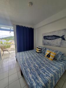 a bedroom with a bed with blue and yellow pillows at OE at Anchorage Hotel in Roseau