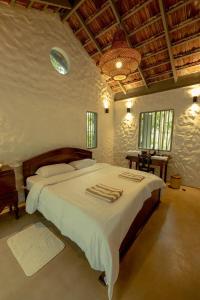 a bedroom with a large bed with towels on it at Clove Bentota in Walagedera