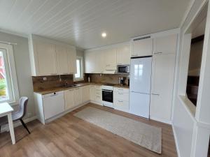 a kitchen with white cabinets and a table and a window at Villa Catharina in Kristinestad