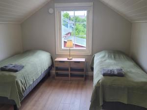 two twin beds in a room with a window at Villa Catharina in Kristinestad
