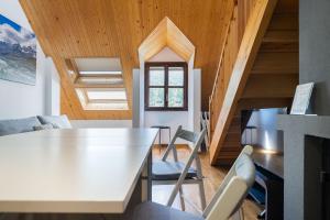 a kitchen and living room with a white table and chairs at Apto Aloha Panticosa | Piscina | WIFI | Vistas in Panticosa