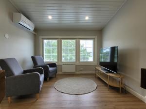 a living room with two chairs and a flat screen tv at Villa Catharina in Kristinestad