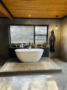 a large white tub in a bathroom with a window at FollyFoot Manor in Midrand +26 photos