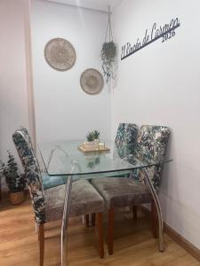a glass table and chairs in a room at El Rincon de Carmen in Felechosa