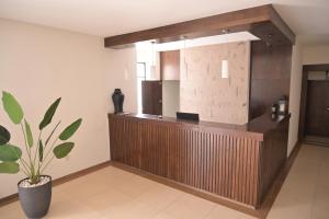 a lobby with a counter and a potted plant at Posada La Noria in Sombrerete